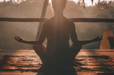 woman doing yoga meditation on brown parquet flooring