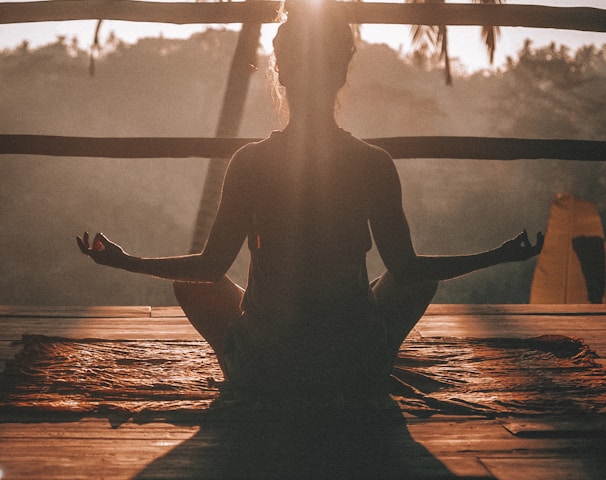 woman doing yoga meditation on brown parquet flooring