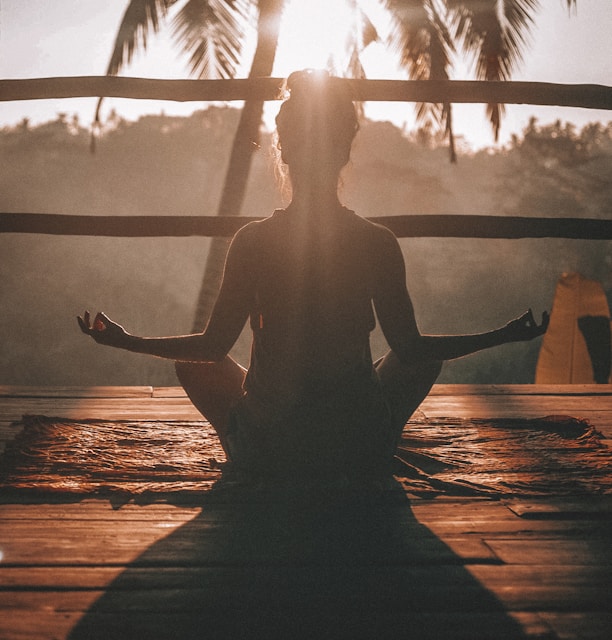 woman doing yoga meditation on brown parquet flooring