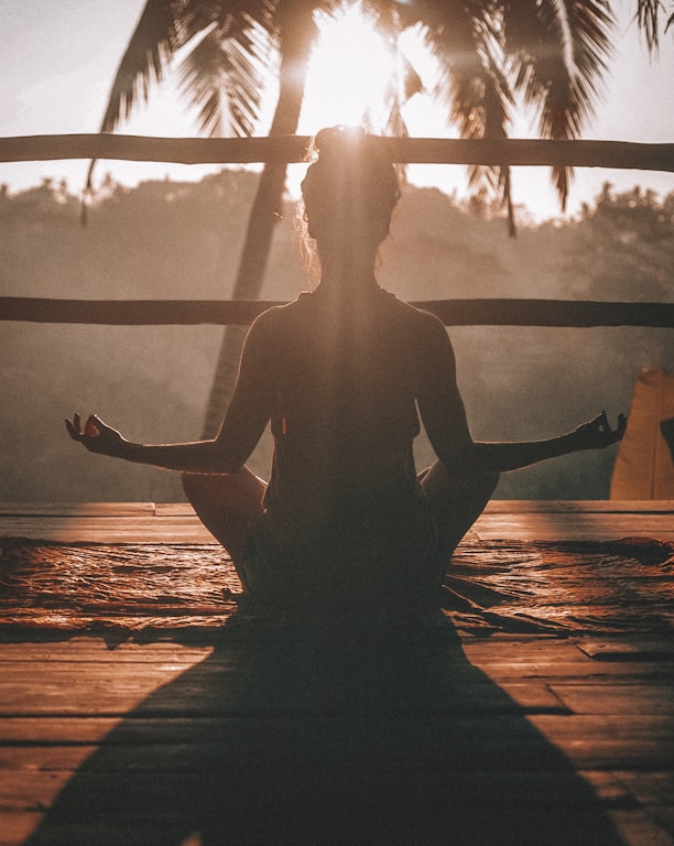 woman doing yoga meditation on brown parquet flooring