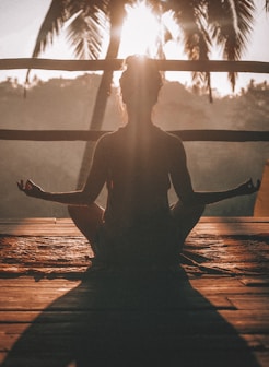 woman doing yoga meditation on brown parquet flooring