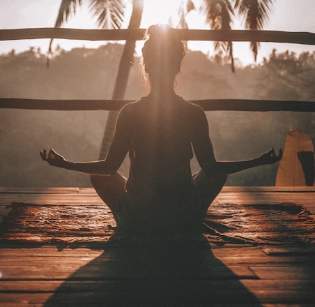 woman doing yoga meditation on brown parquet flooring