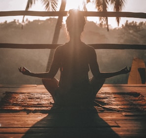 woman doing yoga meditation on brown parquet flooring