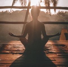 woman doing yoga meditation on brown parquet flooring