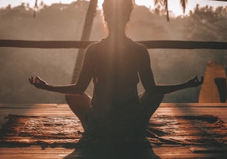 woman doing yoga meditation on brown parquet flooring