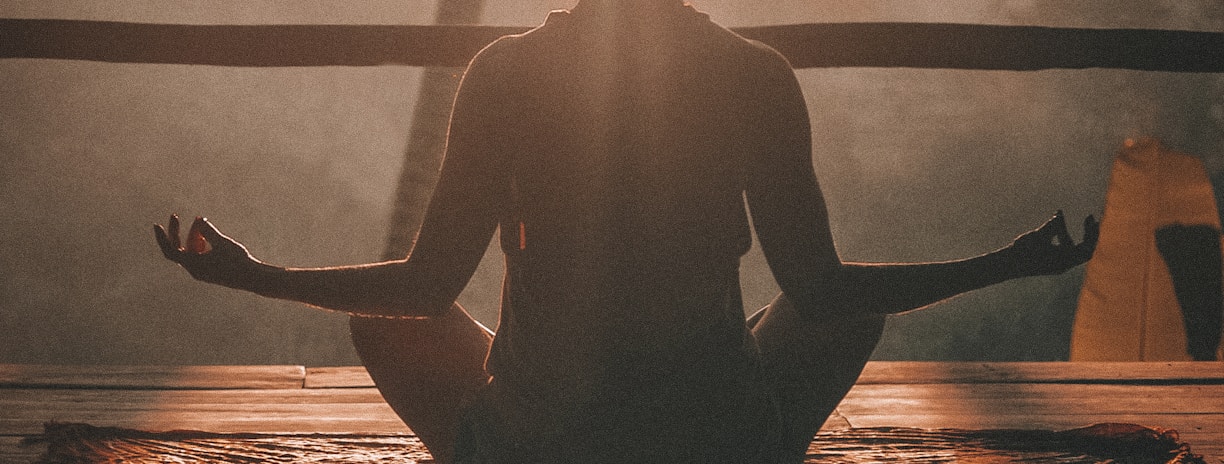 woman doing yoga meditation on brown parquet flooring