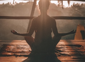 woman doing yoga meditation on brown parquet flooring