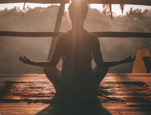 woman doing yoga meditation on brown parquet flooring