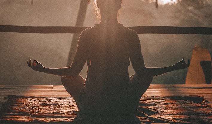 woman doing yoga meditation on brown parquet flooring