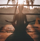 woman doing yoga meditation on brown parquet flooring