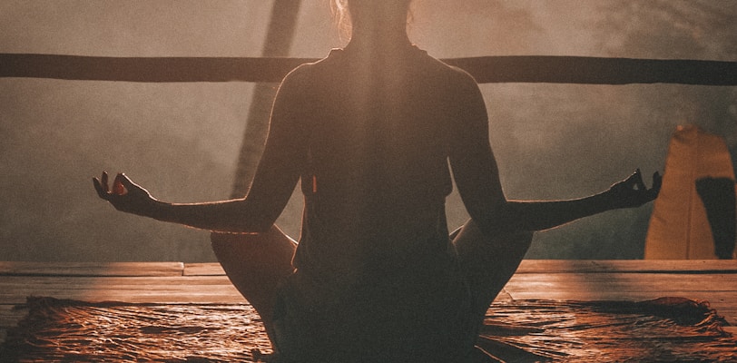 woman doing yoga meditation on brown parquet flooring