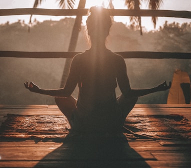 woman doing yoga meditation on brown parquet flooring