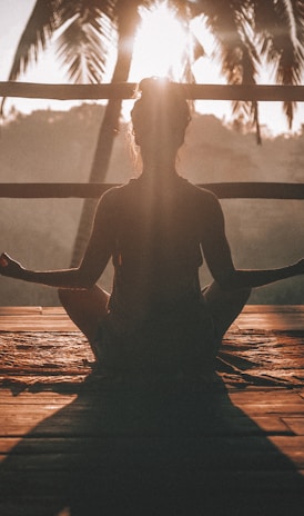 woman doing yoga meditation on brown parquet flooring