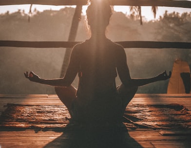 woman doing yoga meditation on brown parquet flooring