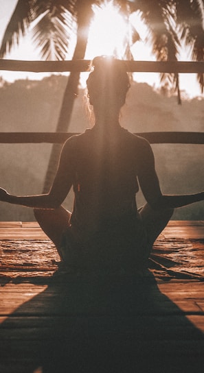 woman doing yoga meditation on brown parquet flooring