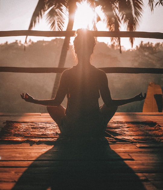 woman doing yoga meditation on brown parquet flooring in Ubud Indonesia