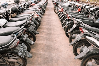 A secure vehicle storage lot with cars and motorcycles parked neatly.