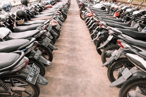 A secure vehicle storage lot with cars and motorcycles parked neatly.