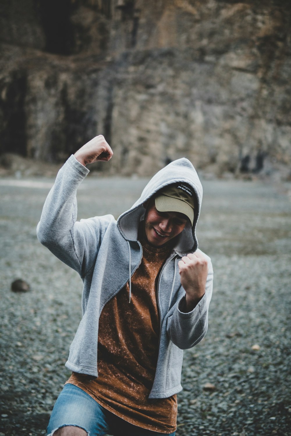 shallow focus photography of man standing in front of rock formation