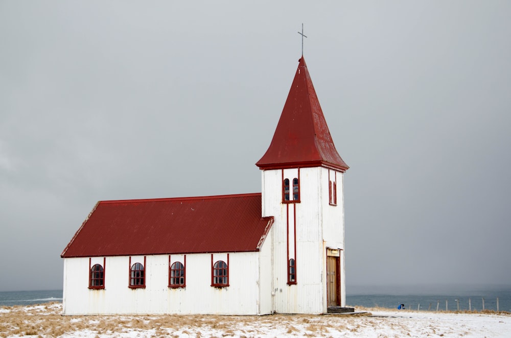 chapel near ocean under grey clouds