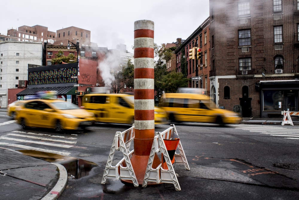 orange and white striped pole near vehicles timelapse photography