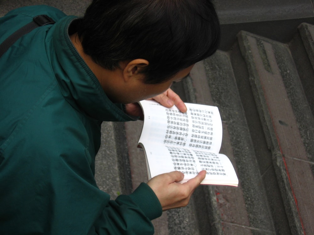 person holding white educational book