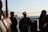 Guests laughing and clinking glasses on the catamaran as the sun dips below the Miami skyline.
