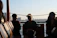Guests laughing and clinking glasses on the catamaran as the sun dips below the Miami skyline.