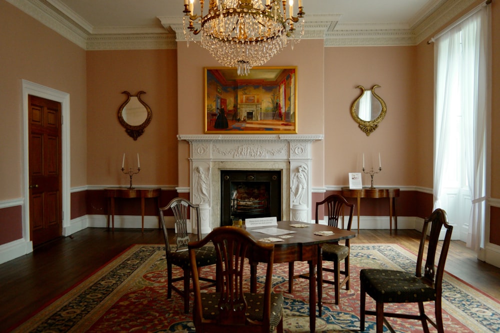 brown wooden table with chairs on red and black rug