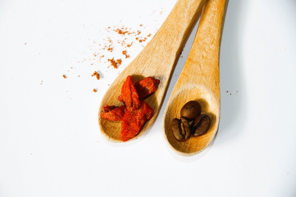 chicchi di caffè su cucchiaio di legno marrone