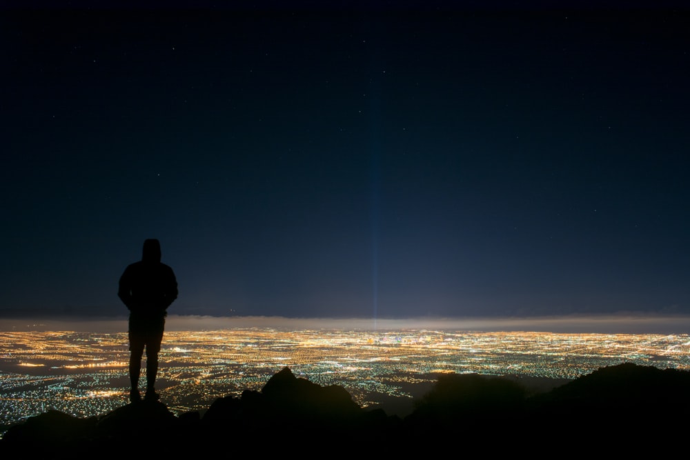 silhouette of man standing on edge