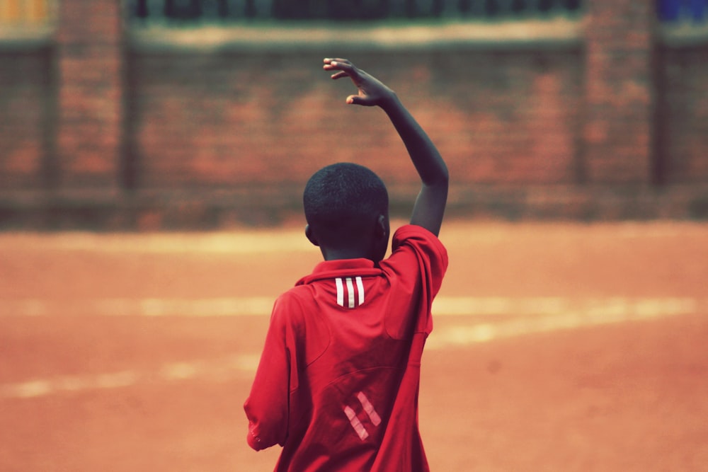 boy raising right hand above head