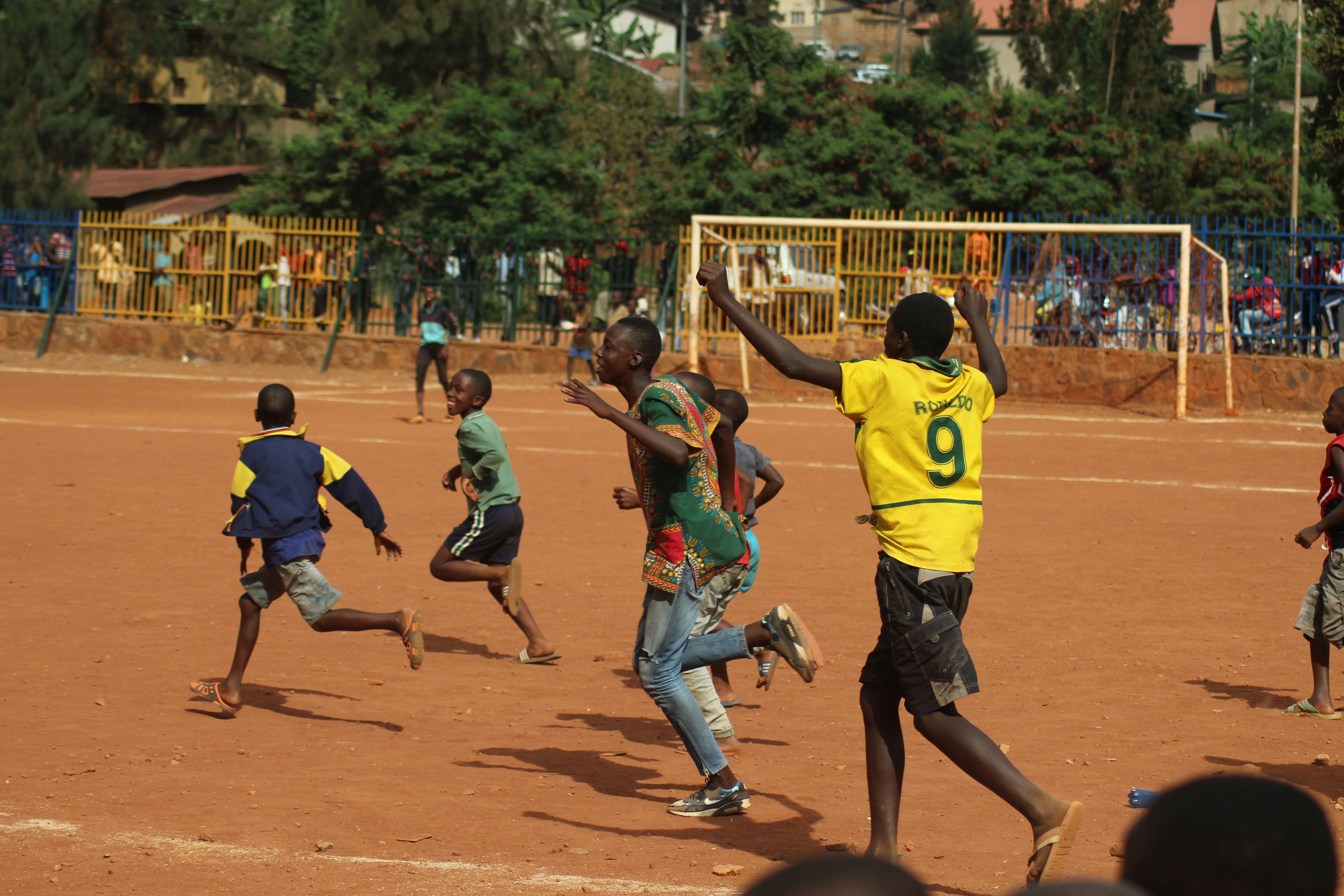 people running on soccer field during daytime