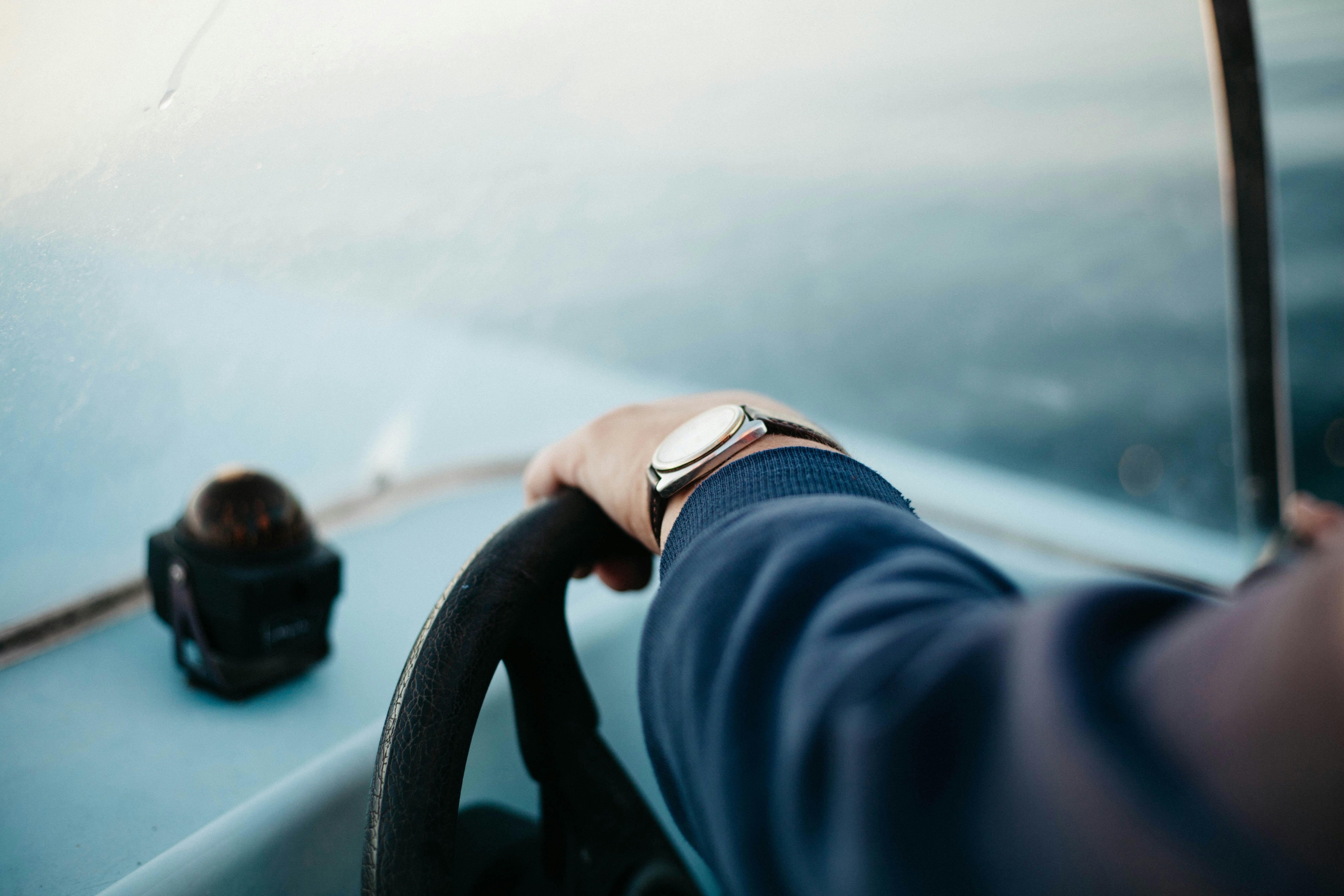 shallow focus photography of person steering boat