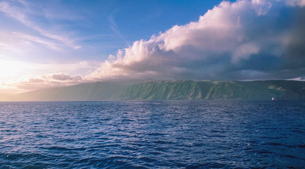 body of water under cloudy sky