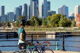 woman holding bicycle looking at the trees