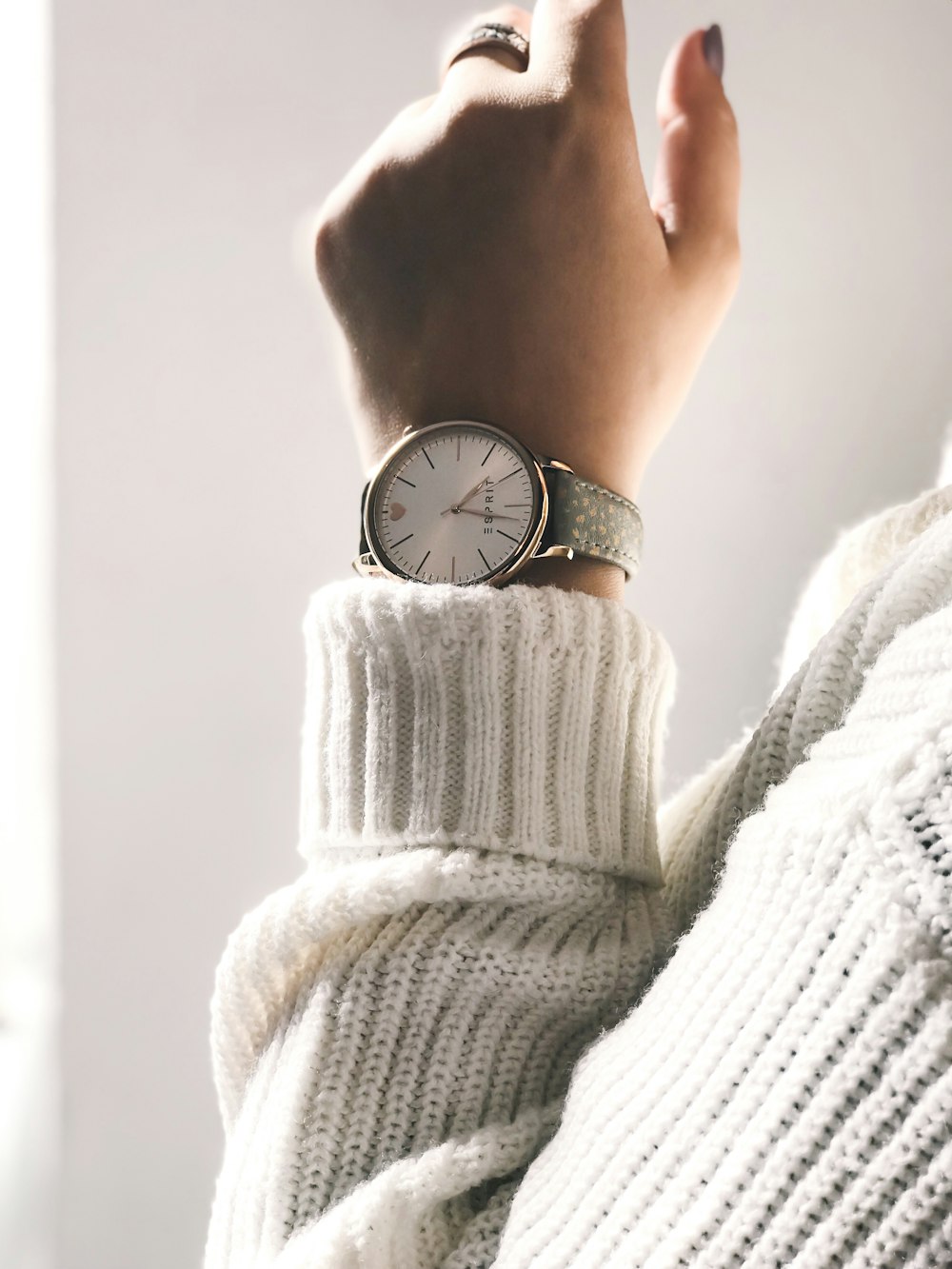 person wearing round silver-colored analog watch