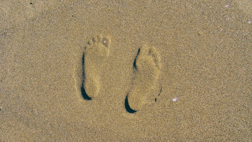 Empreinte de pied d’une personne sur le sable brun