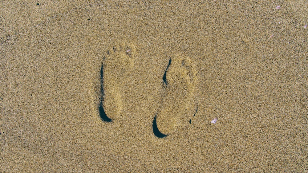 person's foot print on brown sands