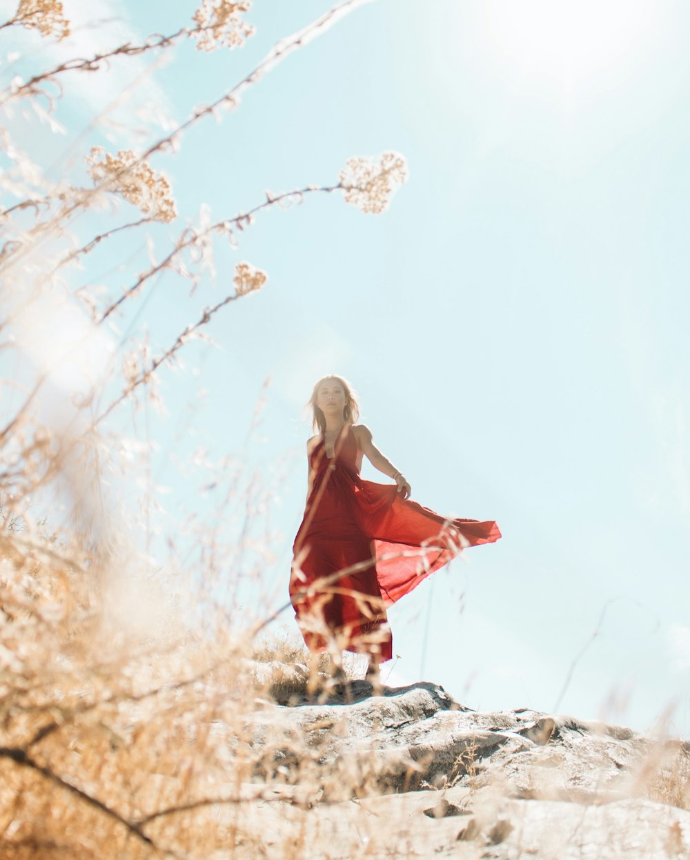 mujer con vestido rojo sin mangas en la cima de la colina