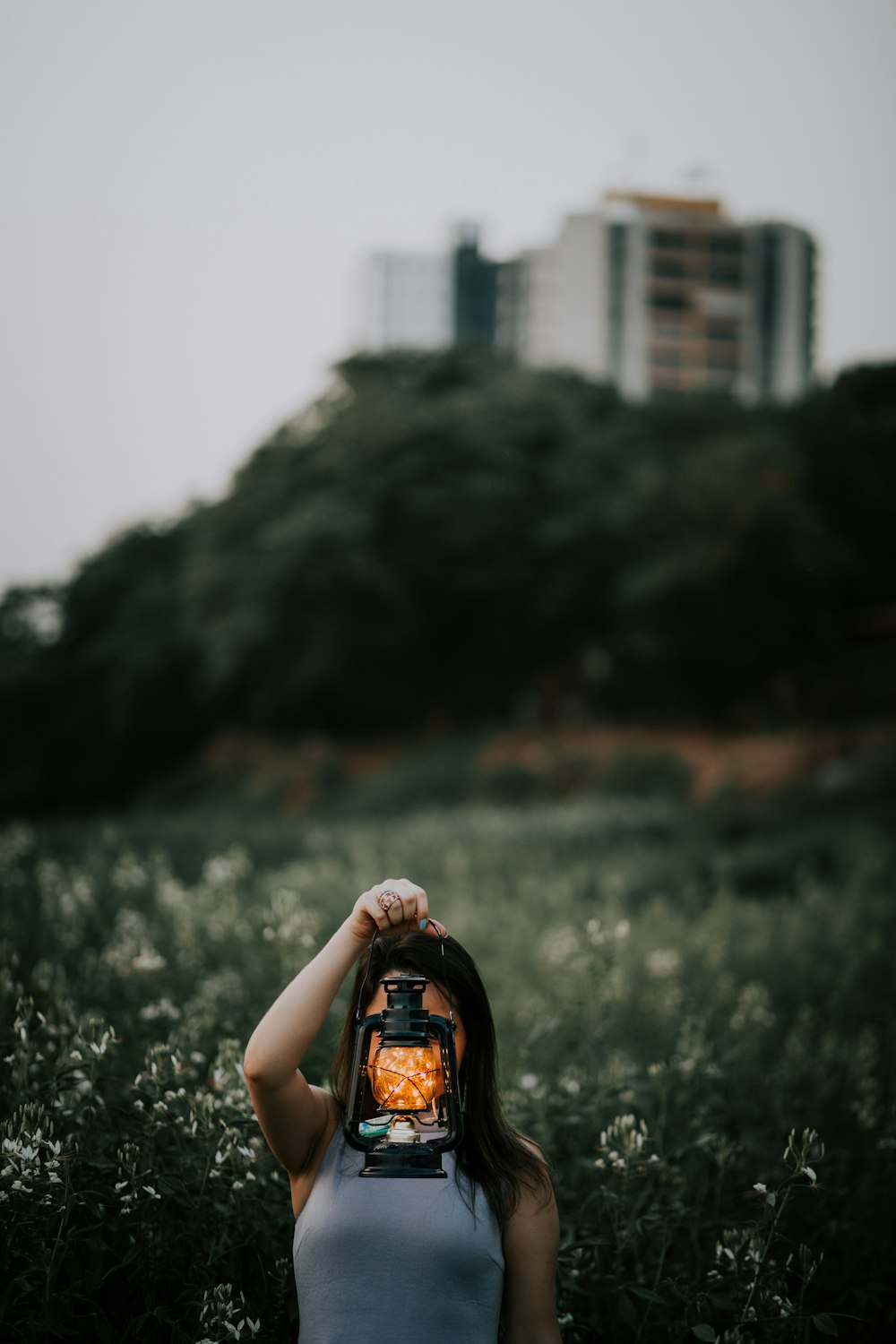 shallow focus photography of woman holding kerosene lamp