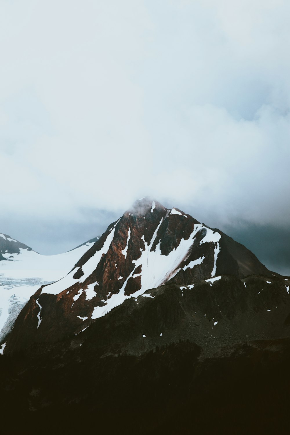 montanha coberta de neve sob céu nublado