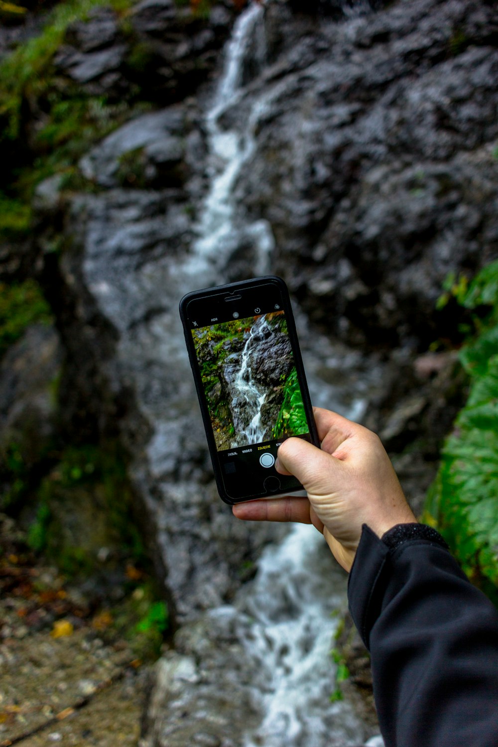 person taking picture of falls