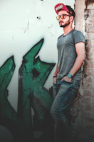 A snap of a cap with the Pimpin Manila logo, worn by someone leaning on a graffiti-covered wall.