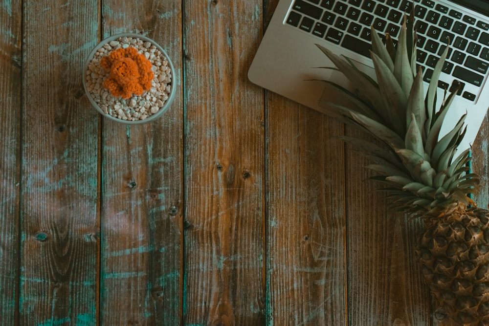 brown pineapple beside MacBook