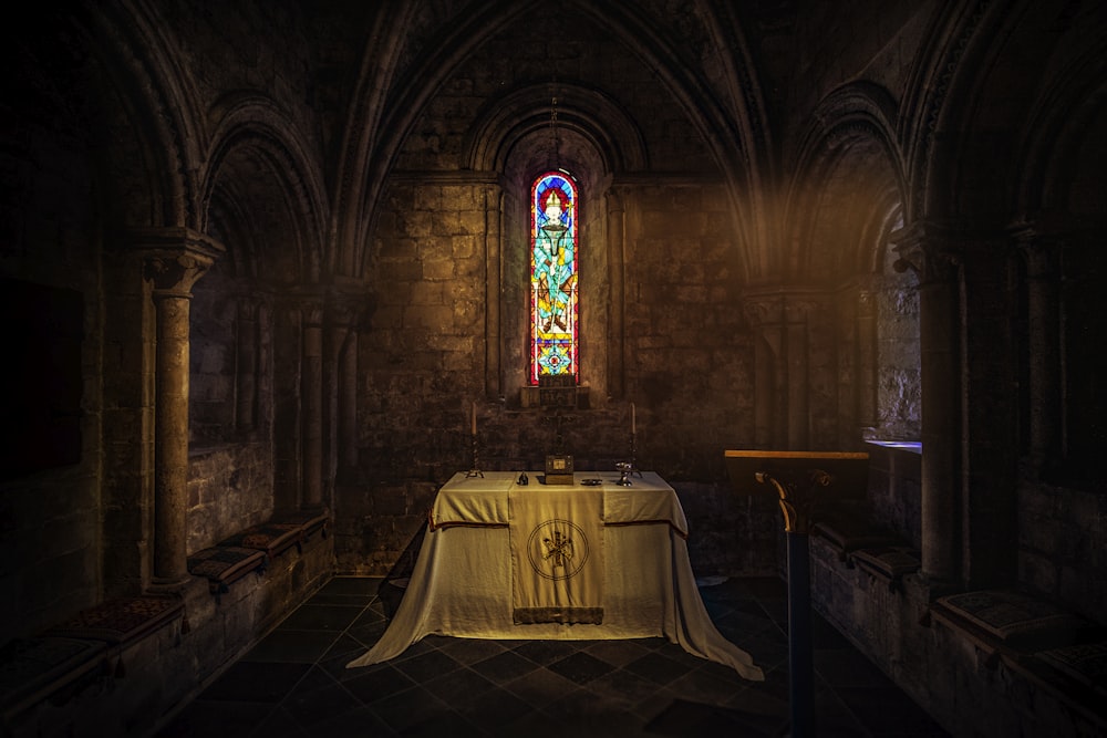 Mesa blanca cerca de la pared marrón dentro de la iglesia