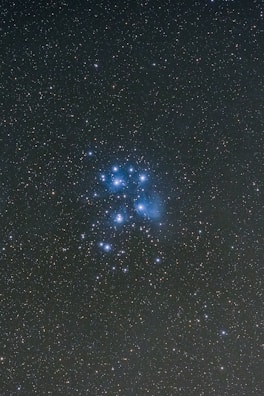 A cluster of bright stars twinkling in a deep blue sky, illustrating the diverse leadership styles shining together.