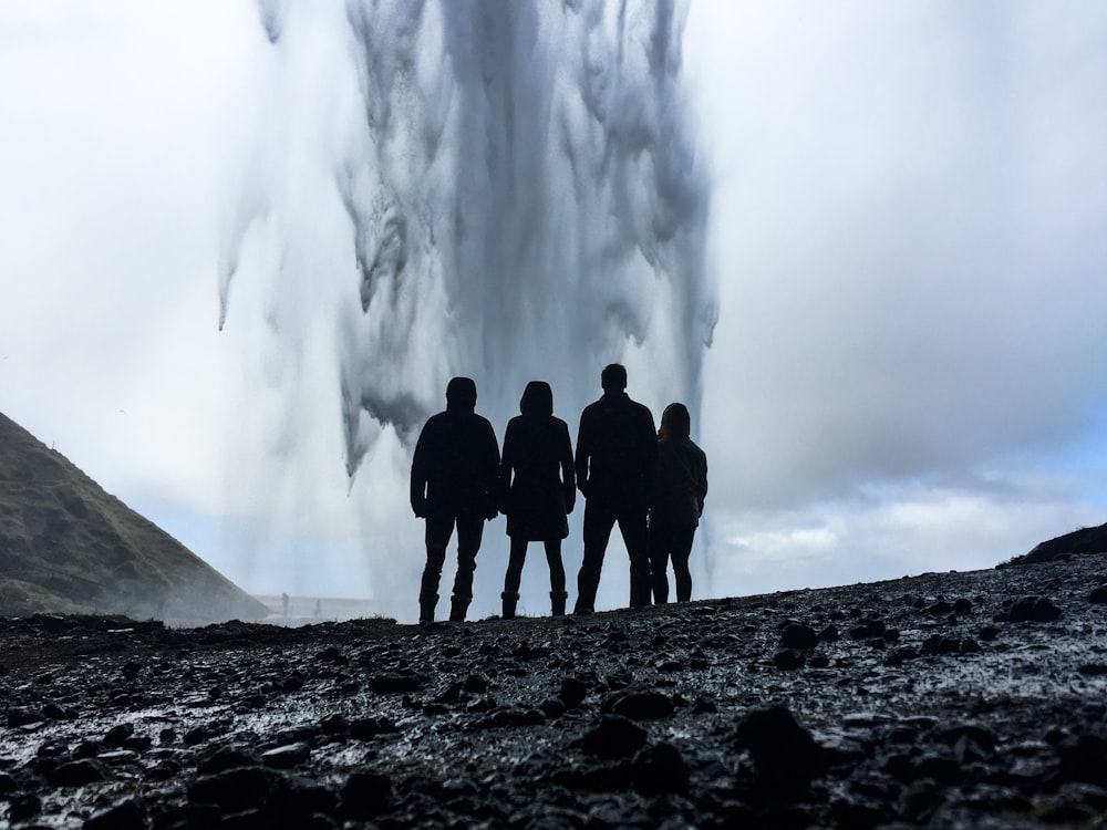 four person's looking at geyser