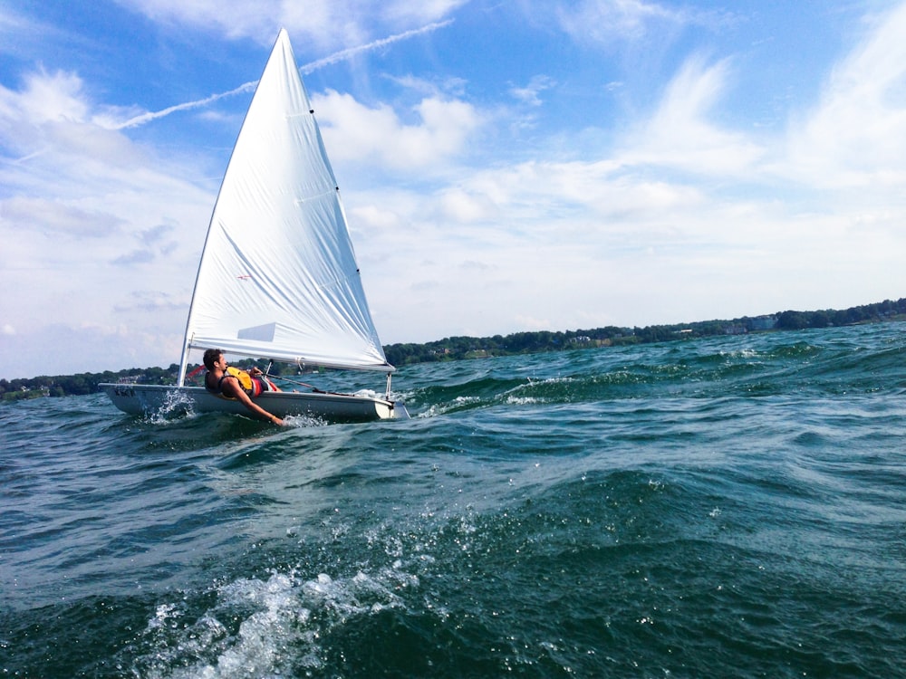 person riding boat under cloudy sky