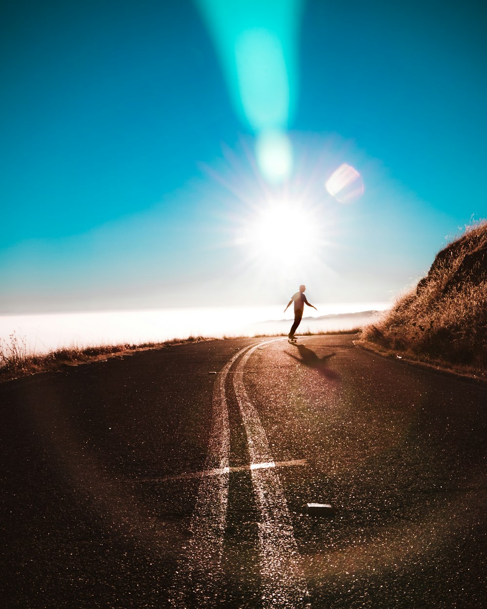 silhouette of person riding on skateboard during daytime